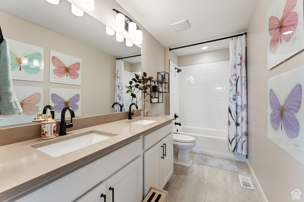 Full bathroom with double vanity, shower / bath combo with shower curtain, toilet, recessed lighting, and tile patterned floors