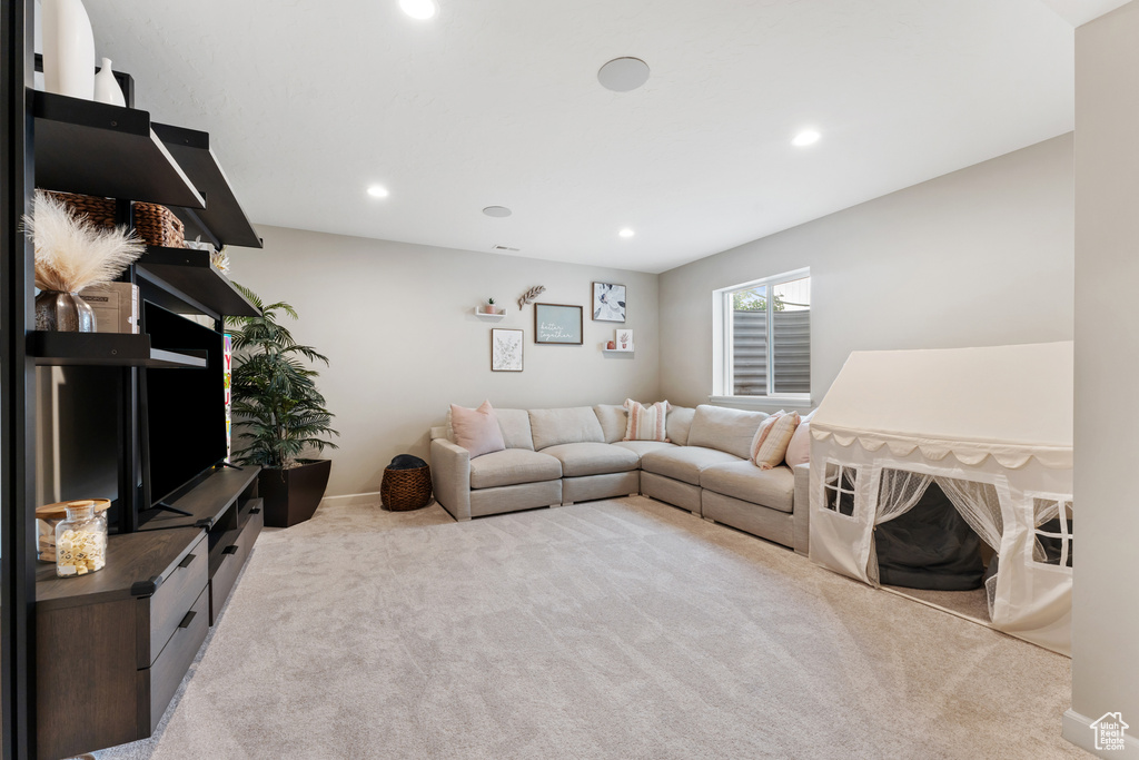 Carpeted living area featuring recessed lighting and baseboards