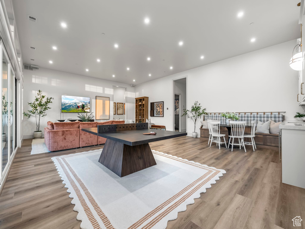 Kitchen with open floor plan, a center island, light wood-type flooring, dark countertops, and recessed lighting