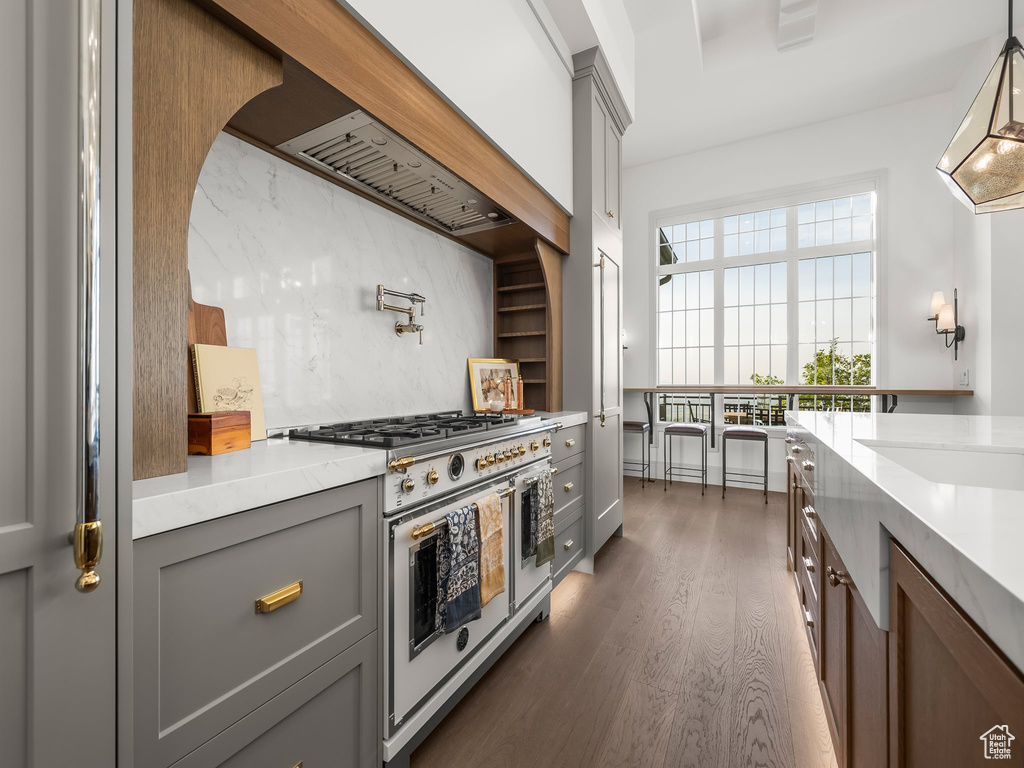 Kitchen with range with two ovens, gray cabinets, light countertops, dark wood-type flooring, and pendant lighting