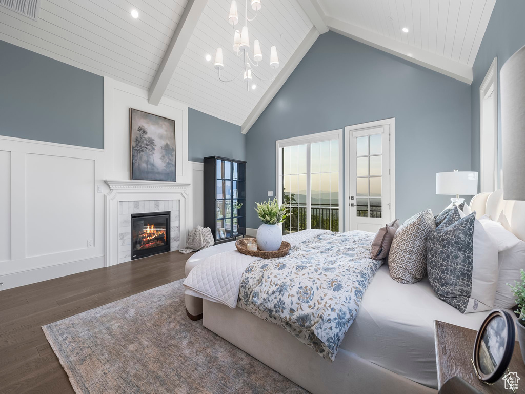Bedroom featuring wood finished floors, a tile fireplace, a chandelier, wooden ceiling with exposed beams, and high vaulted ceiling