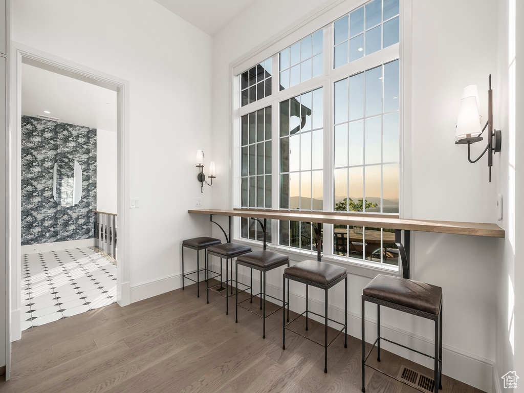 Dining area with baseboards, plenty of natural light, and wood finished floors