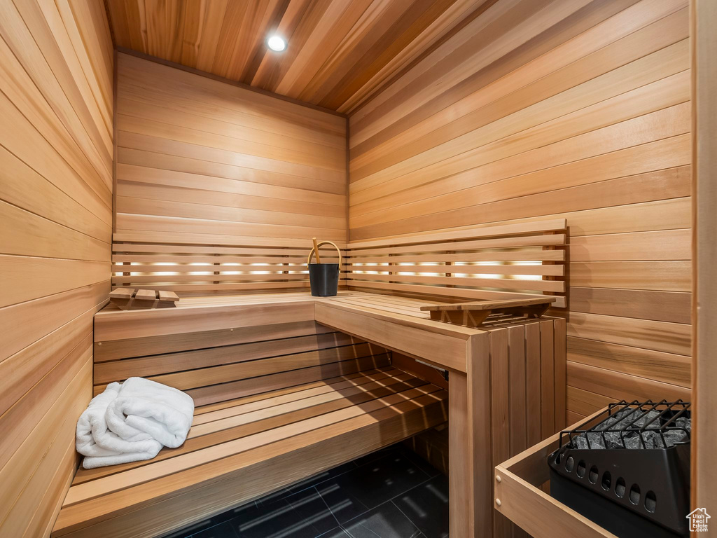 Relaxing sauna / steam room with wood ceiling, wood walls, tile patterned flooring, and recessed lighting