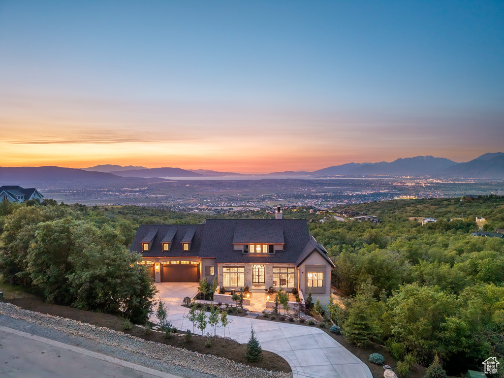 View of front of house with a mountain view, driveway, and a garage