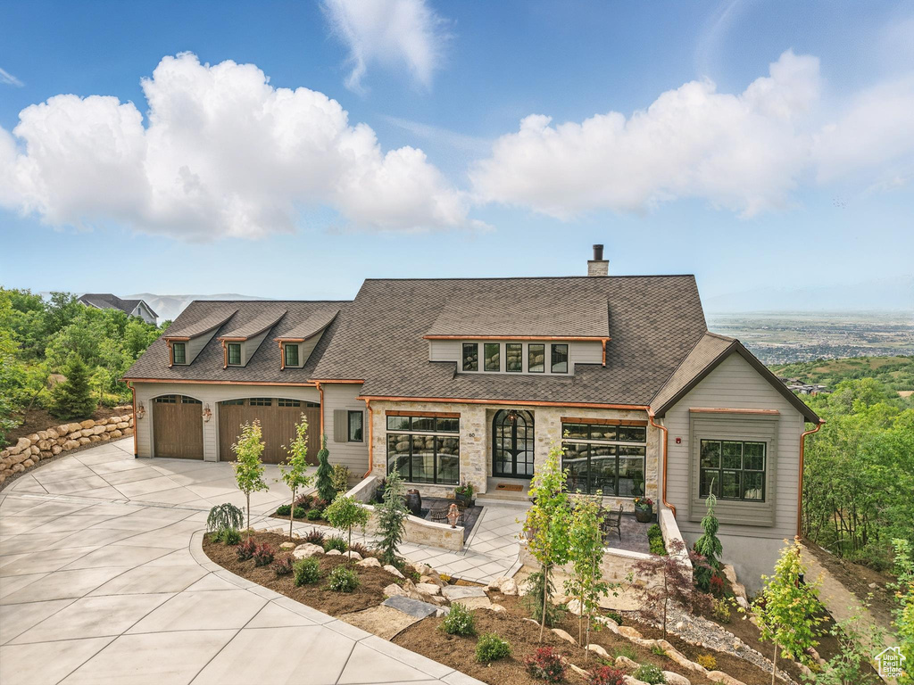 View of front facade featuring driveway and a chimney