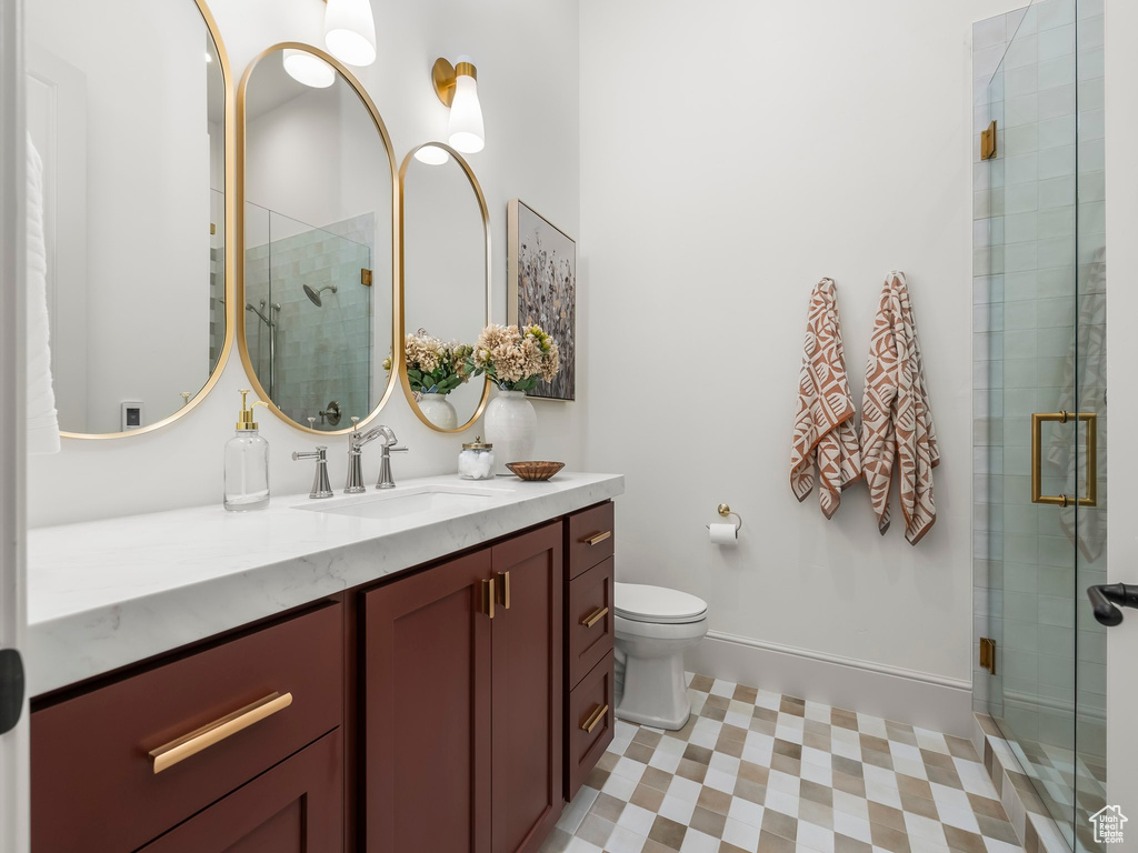 Full bath featuring vanity, tile patterned floors, a shower stall, and toilet