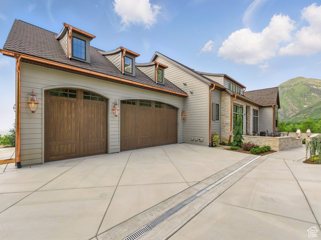 View of front of property featuring an attached garage, driveway, and a mountain view