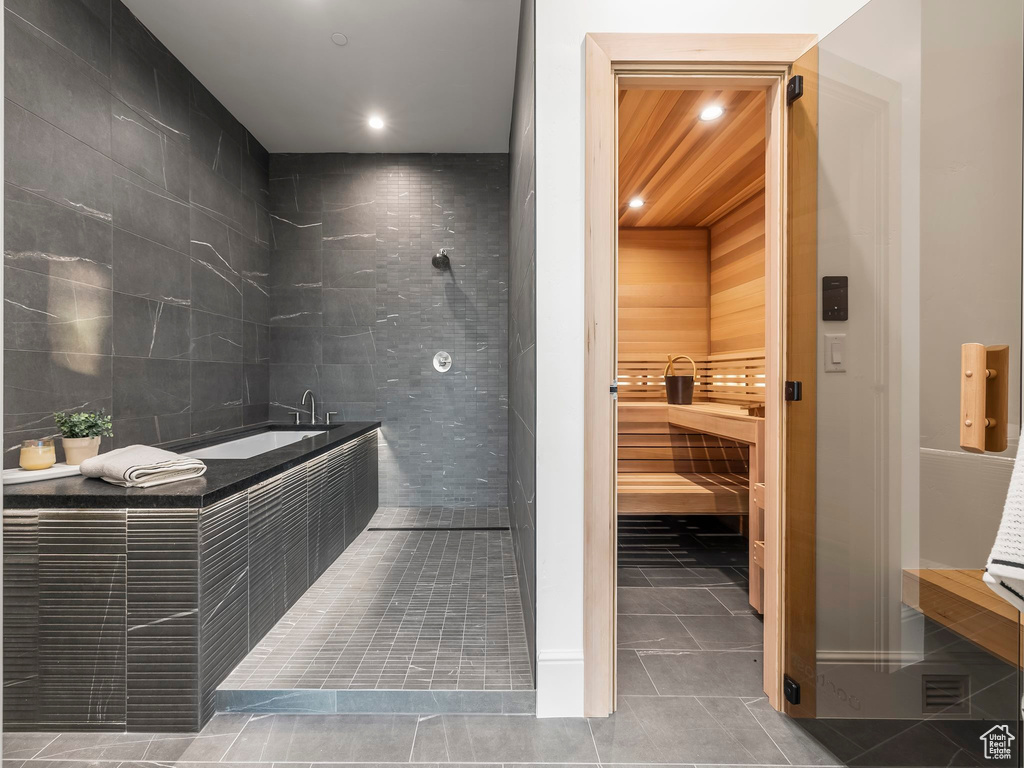 Relaxing sauna with tile patterned floors and recessed lighting