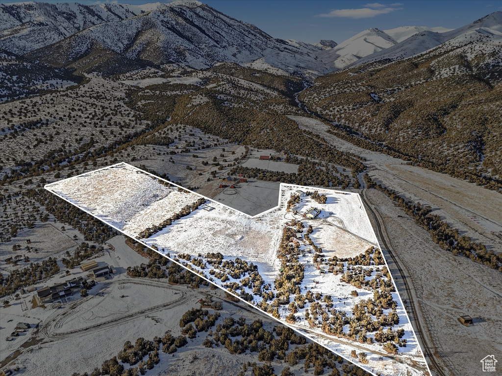 Aerial view of property and surrounding area with a mountain backdrop and property parcel outlined