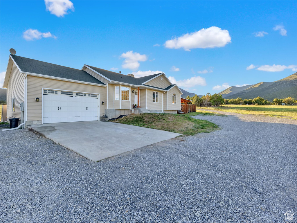 Ranch-style home with driveway, an attached garage, and a mountain view