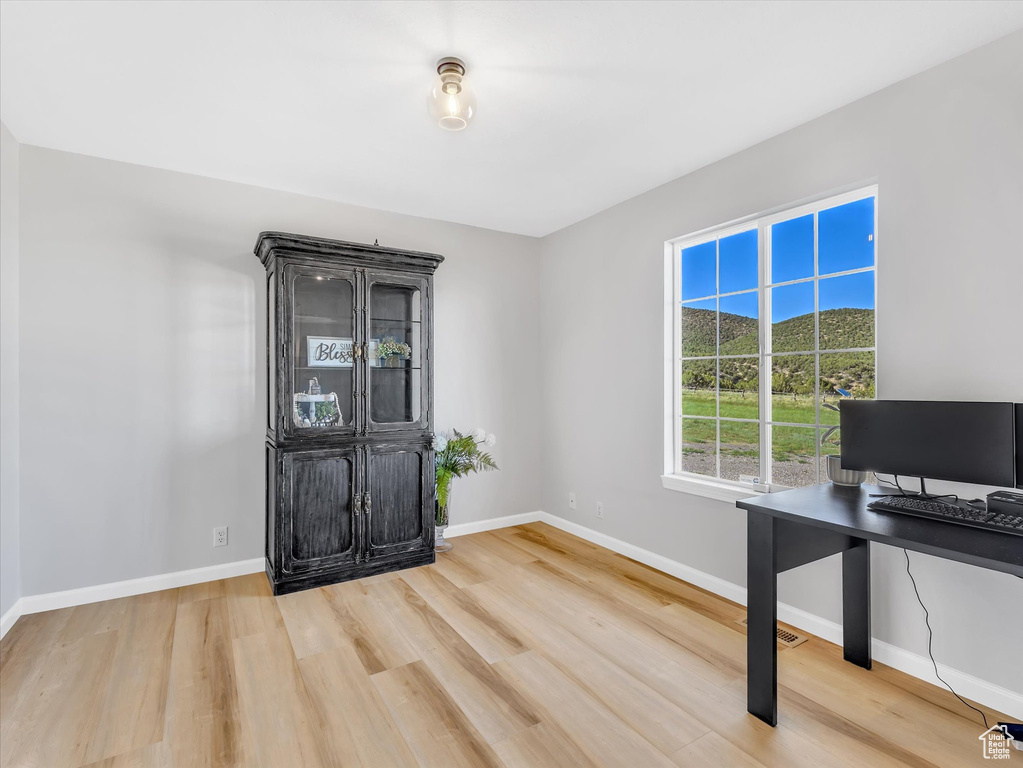 Unfurnished office with wood finished floors and baseboards