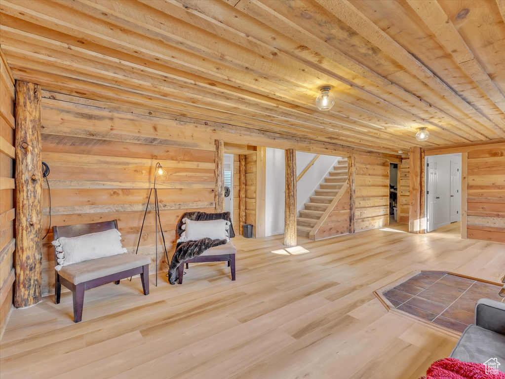 Unfurnished room featuring stairway, wood finished floors, wood ceiling, and wood walls