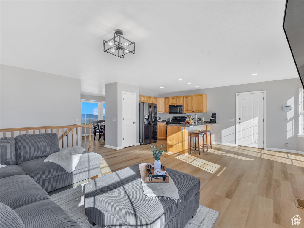 Living area featuring recessed lighting, baseboards, and light wood-style floors