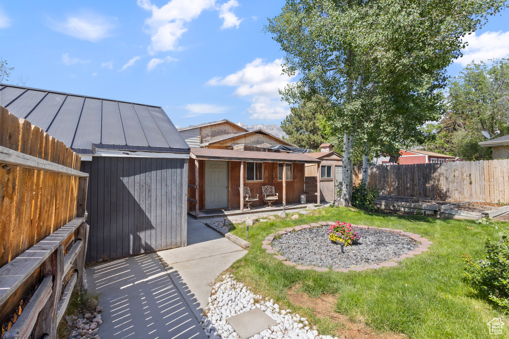Rear view of property with a porch and a storage shed