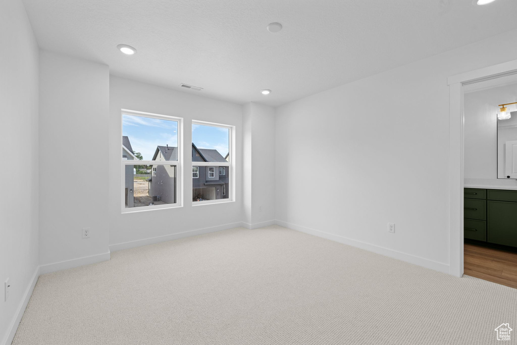 Unfurnished room with light carpet, baseboards, and recessed lighting