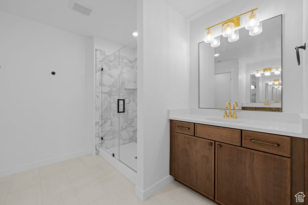 Full bathroom featuring vanity, a marble finish shower, and baseboards