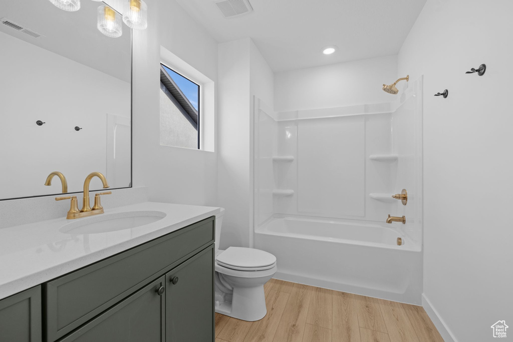 Full bathroom with vanity, wood finished floors, toilet, bathing tub / shower combination, and recessed lighting