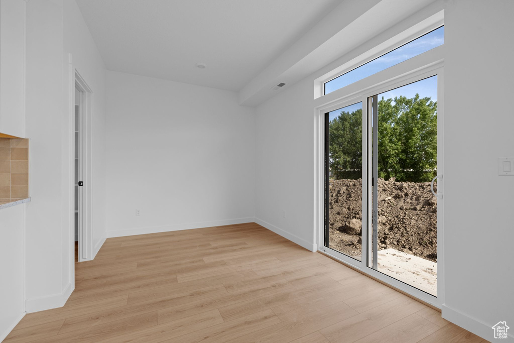 Spare room featuring light wood-type flooring and baseboards