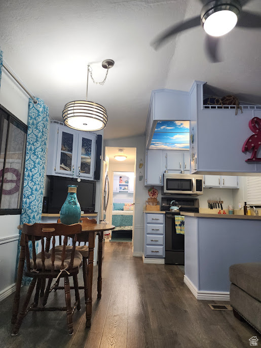 Kitchen with electric range, stainless steel microwave, dark wood-style flooring, pendant lighting, and baseboards