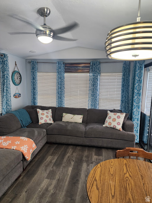 Living room featuring lofted ceiling, a ceiling fan, and wood finished floors