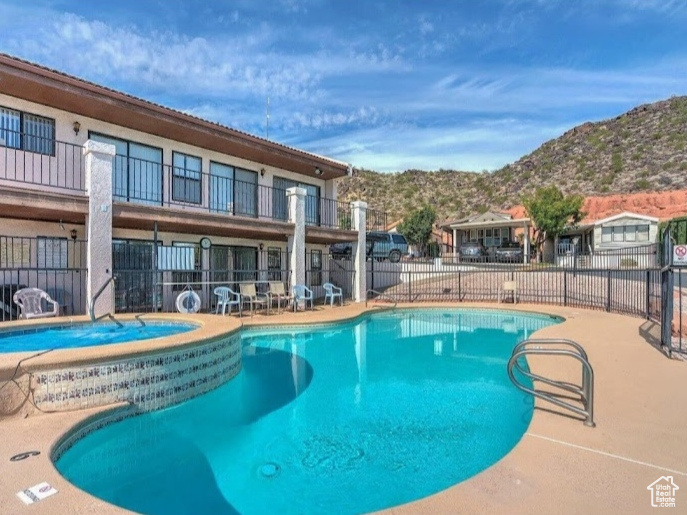 Community pool with a mountain view and a community hot tub