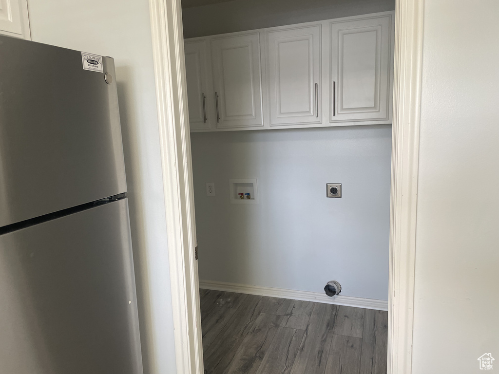 Laundry room featuring cabinet space, hookup for a washing machine, hookup for an electric dryer, dark wood finished floors, and baseboards