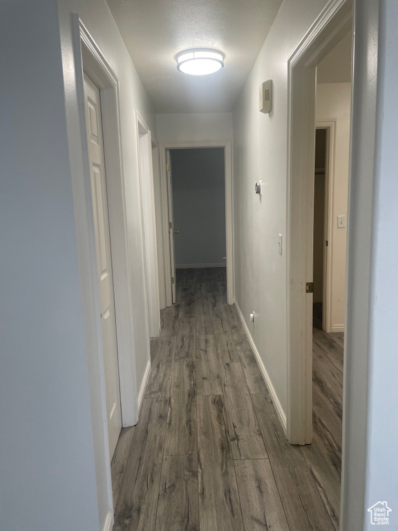 Corridor with wood finished floors and baseboards