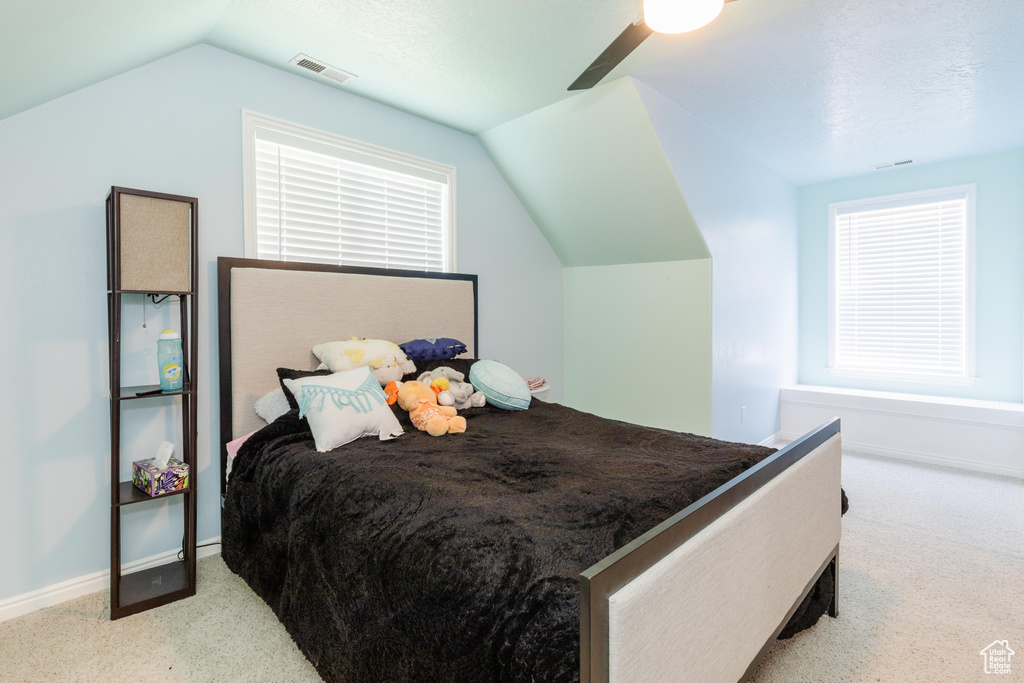 Carpeted bedroom featuring lofted ceiling, ceiling fan, and baseboards