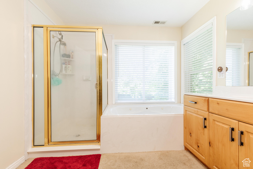 Full bath featuring vanity, a stall shower, and a garden tub