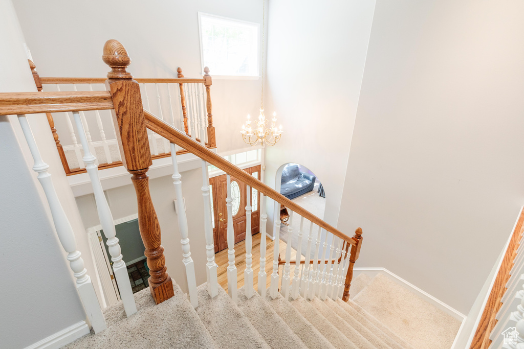 Stairway featuring baseboards and a chandelier