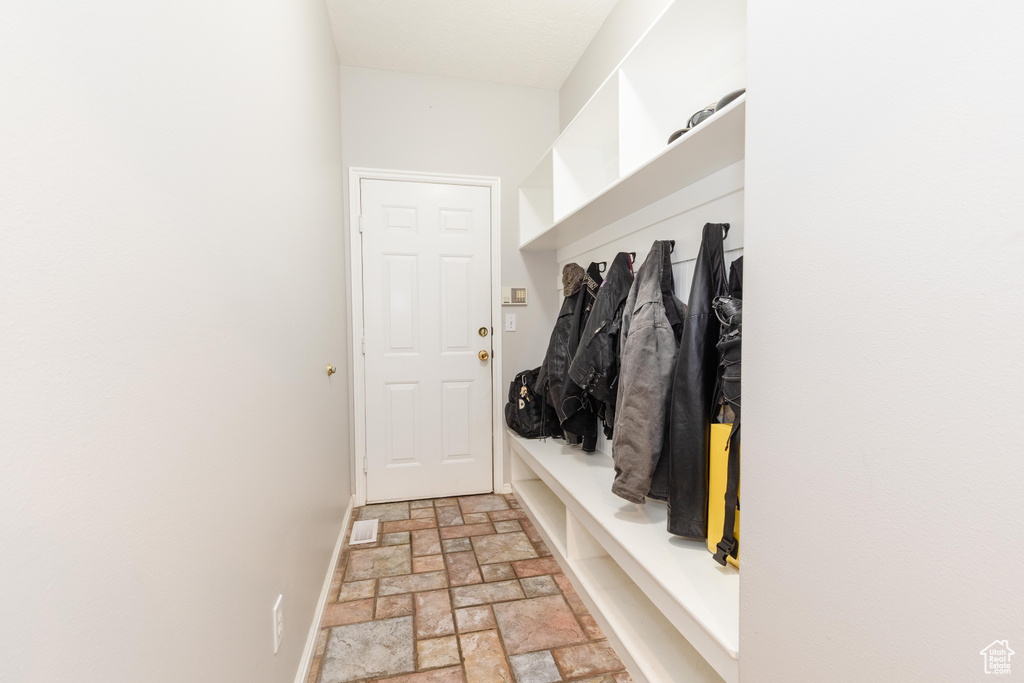 Mudroom with stone tile floors and baseboards