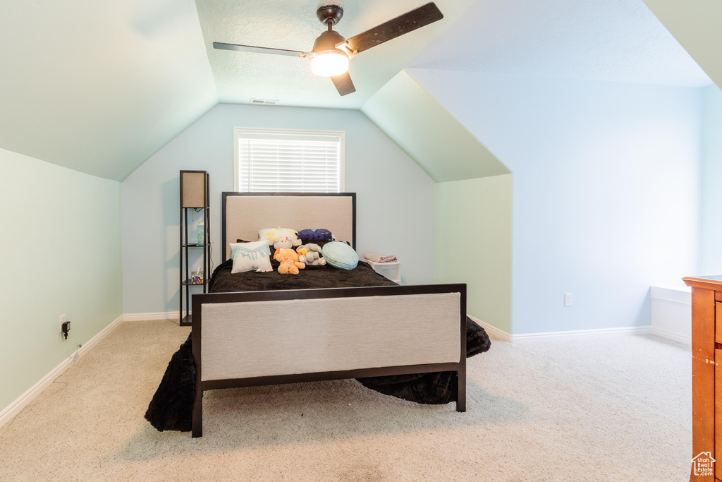 Bedroom with vaulted ceiling, carpet floors, a ceiling fan, and baseboards