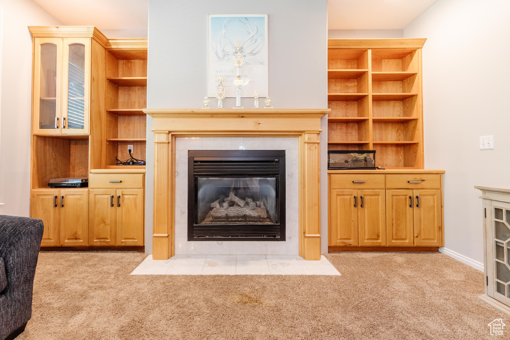 Living area featuring a tile fireplace and light colored carpet