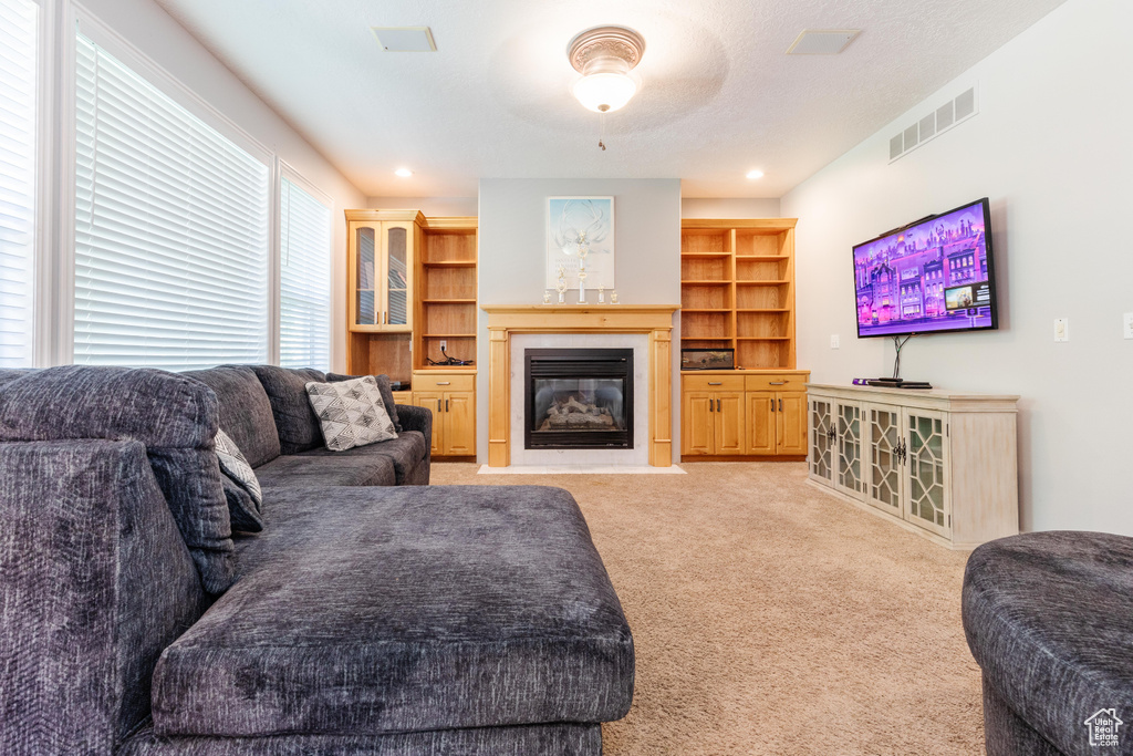 Living room with light colored carpet and a fireplace with flush hearth