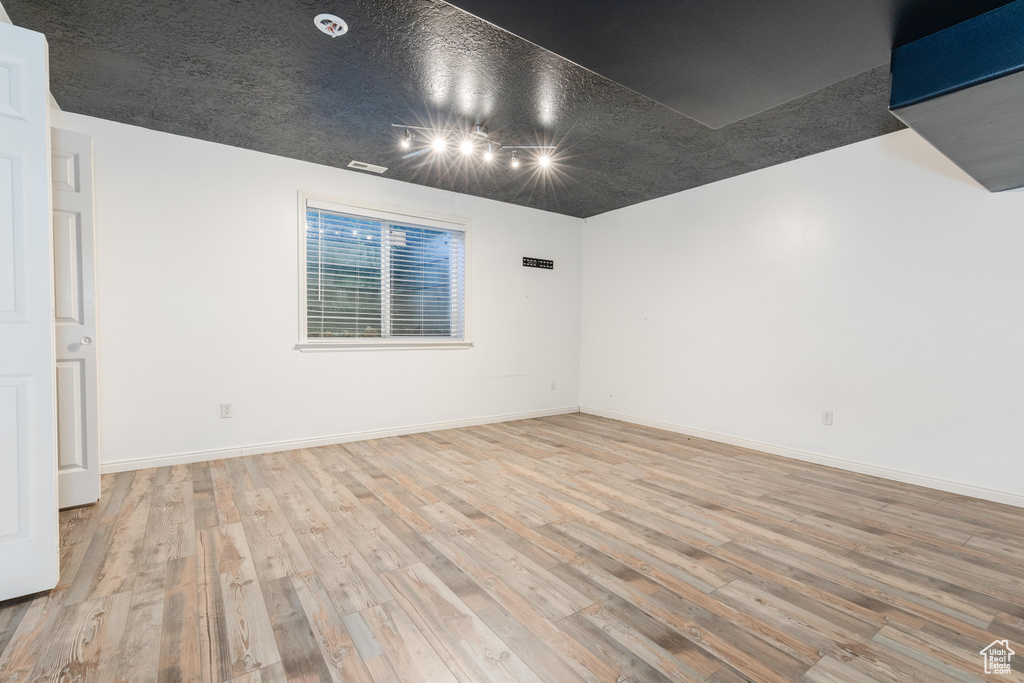 Unfurnished room with wood finished floors and baseboards