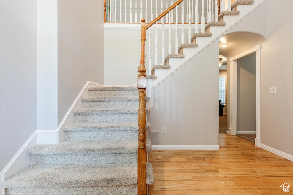 Stairway with wood finished floors and baseboards
