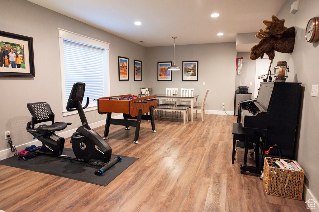 Exercise area with baseboards, light wood-type flooring, and recessed lighting