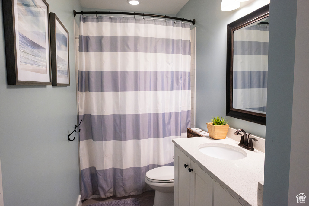 Full bathroom featuring vanity, toilet, and curtained shower