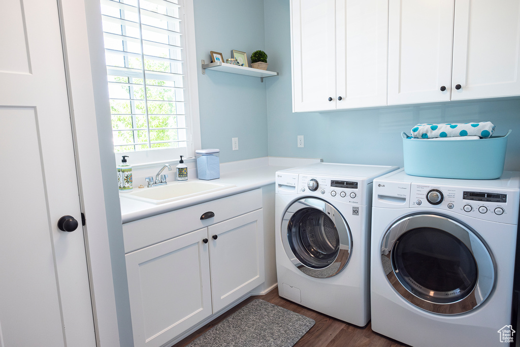 Laundry area featuring cabinet space, washing machine and dryer, and dark wood-type flooring