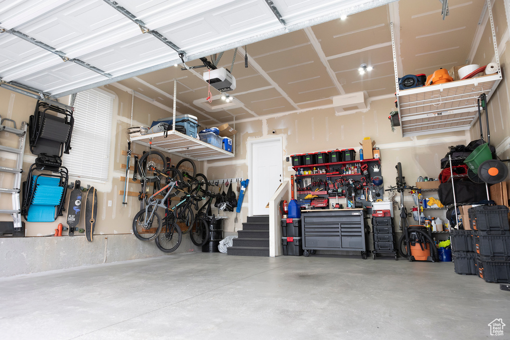 Garage featuring a garage door opener and a workshop area