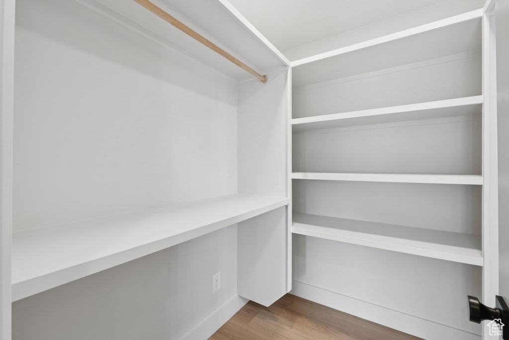 Walk in closet with wood finished floors