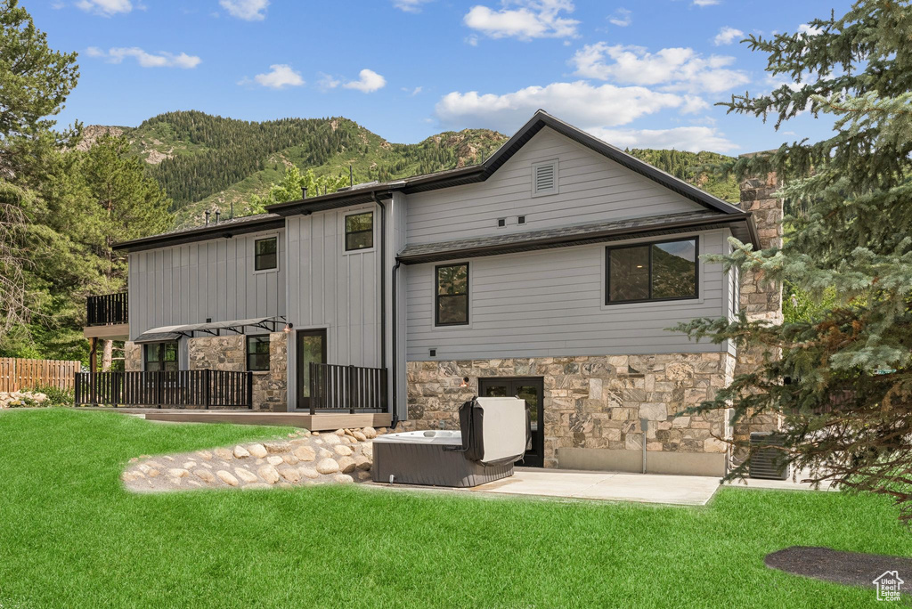 Rear view of house featuring stone siding and a mountain view