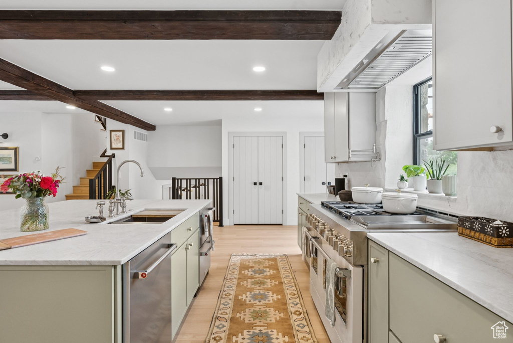 Kitchen with range with two ovens, dishwasher, premium range hood, beam ceiling, and light wood-type flooring
