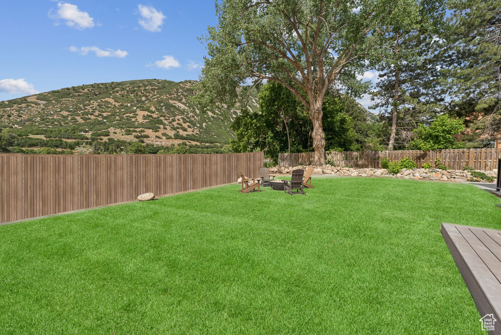 Fenced backyard featuring a mountain view