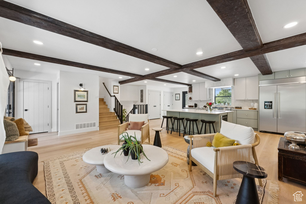 Living room with light wood finished floors, stairway, beam ceiling, recessed lighting, and coffered ceiling