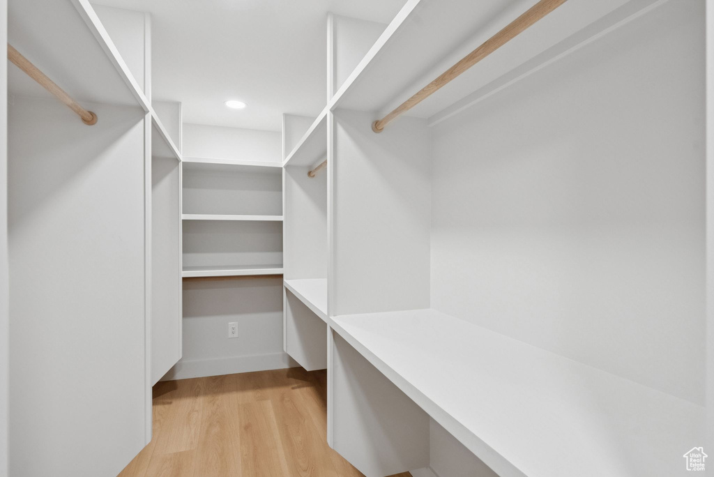 Walk in closet with light wood finished floors