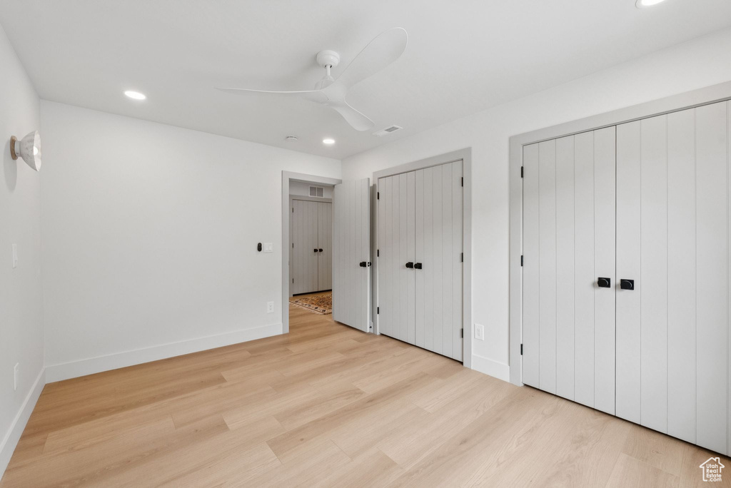 Unfurnished bedroom featuring two closets, recessed lighting, light wood-style flooring, and ceiling fan