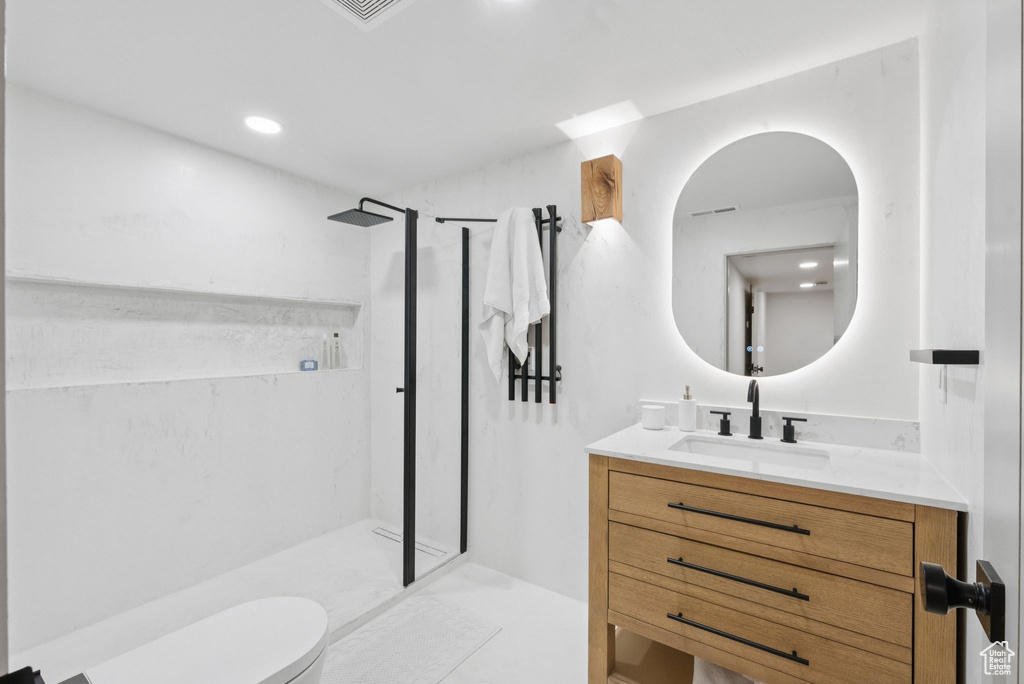 Full bathroom featuring a marble finish shower, vanity, and recessed lighting