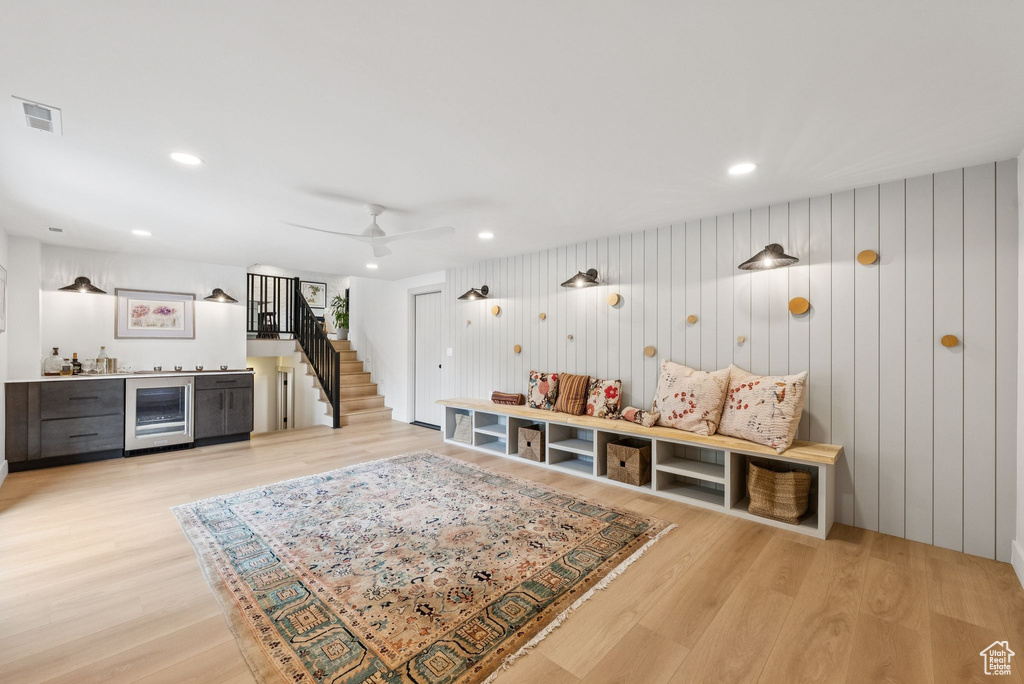 Game room with bar with sink, wine cooler, light wood-style floors, a ceiling fan, and recessed lighting