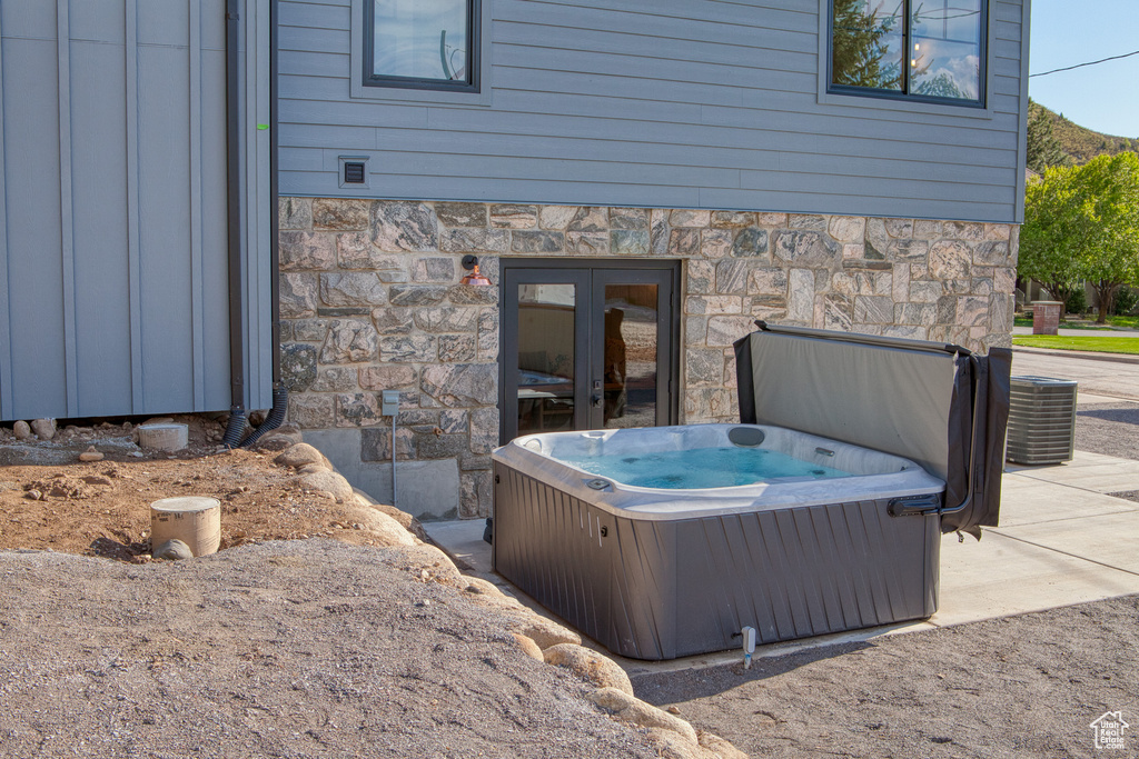 View of patio / terrace featuring a hot tub, french doors, and central air condition unit